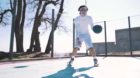 Portrait of a Basketball Player Dribbling the Ball with Skill on an Outdoor Basketball Court Slow