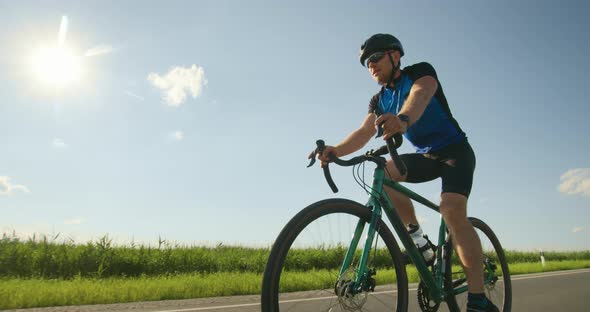 A Sportsman on a Bicycle is Slowly Riding Along the Track