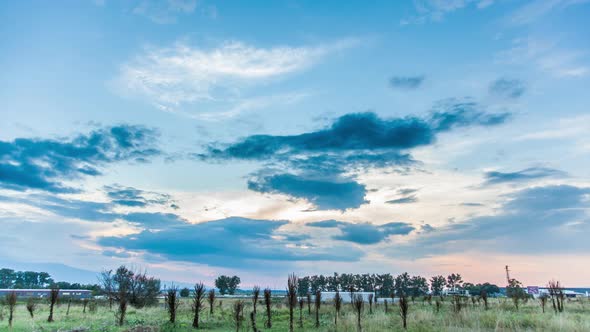 Sunset over cloudy sky and field