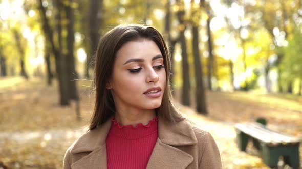 Passionate Look Into Camera of Brunette with Brown Eyes During a Walk in Park