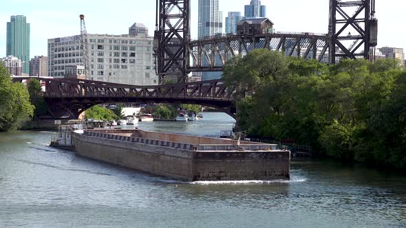 barge sails on a river past old bridges 4k