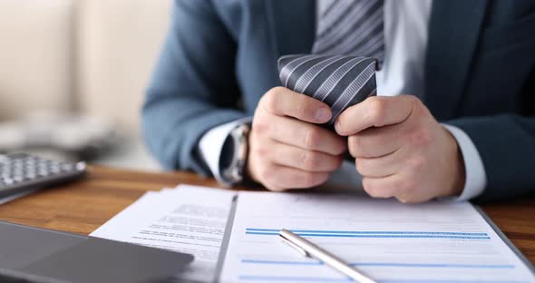 Businessman Nervously Touches Tie at Workplace Closeup