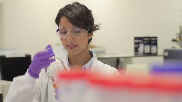 Scientist looking at liquid in laboratory