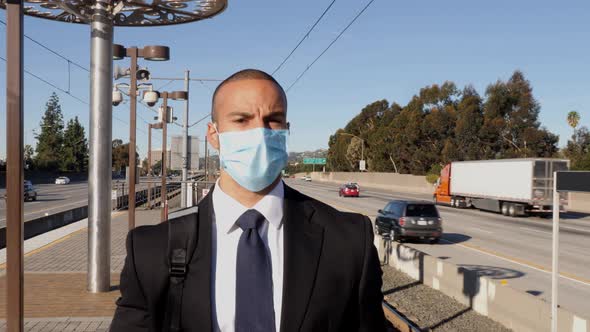 Businessman wearing a face mask waits for train