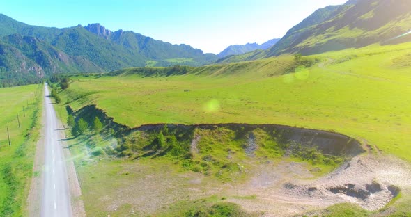 Aerial Rural Mountain Road and Meadow at Sunny Summer Morning. Asphalt Highway and River.