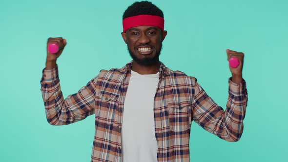 Sporty African American Man Working Out Pumping Up Arm Muscles Lifting Dumbbells Practicing Pilates