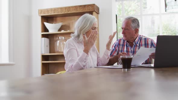 Stressed senior couple with laptop checking finances at home
