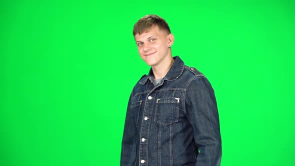 Young Man Walking and Greeting on a Green Screen, Chroma Key. Slow Motion