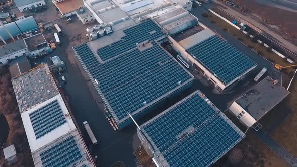 Top view of solar power station on roofs. View from the air on the buildings with blue solar panels.