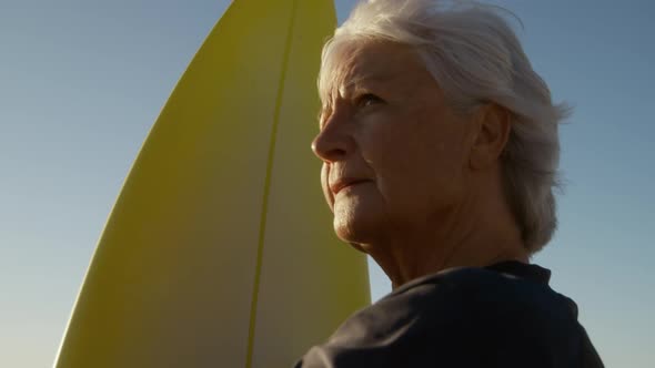 Senior woman with a surfboard at the beach