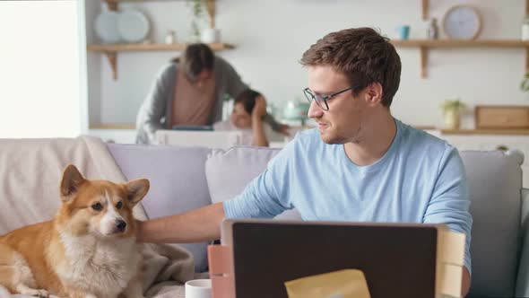 Busy Father Working Remotely with Laptop Sitting