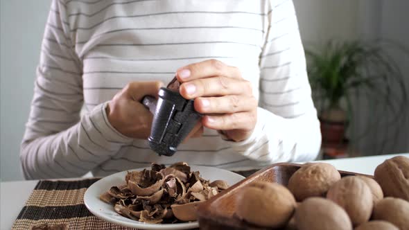 Young Woman Is Cracking a Walnuts at Domestic Room