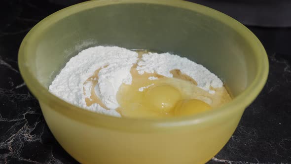 Sugar Is Poured Into a Bowl with Flour and Eggs.
