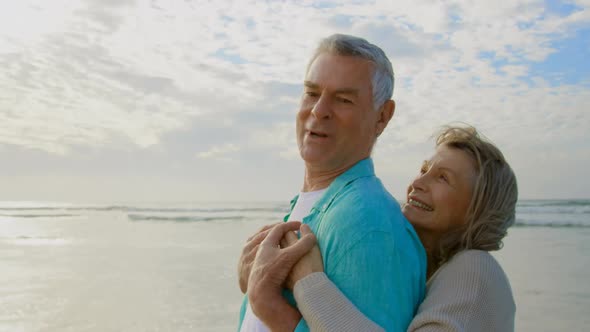 Active senior Caucasian couple embracing each other on the beach 4k