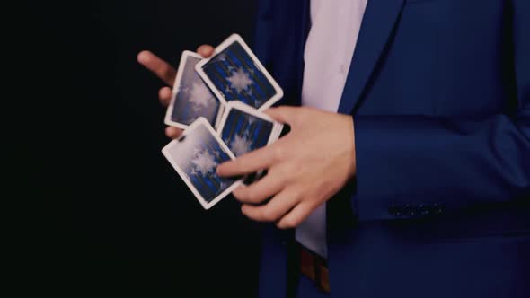 The Magician Shows Tricks with Playing Cards