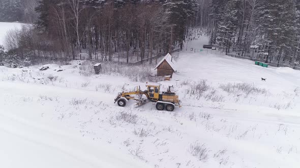 Aerial view of Snowblower Grader Clears Snow Covered Road next to the forest 10
