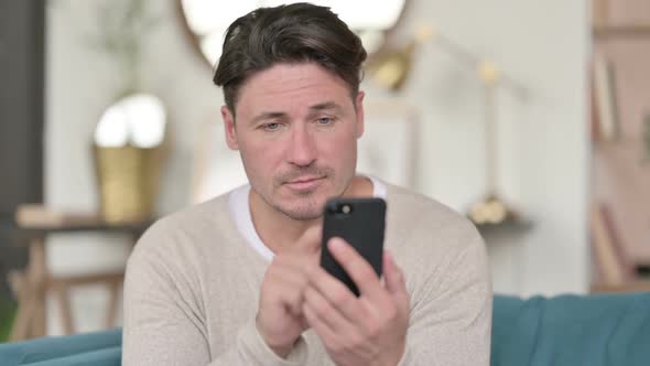 Middle Aged Man Using Smartphone at Home