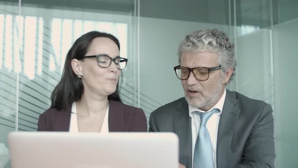 Middle-aged Boss in Eyeglasses Discussing with Female Assistant