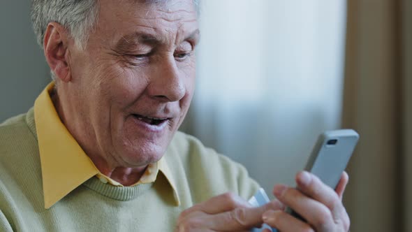 Close Up Smiling Elderly Man Makes Internet Order Using Mobile Phone Happy Senior Holding Credit
