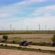 Tractor Driving On The Road With Windmills In The Background - VideoHive Item for Sale