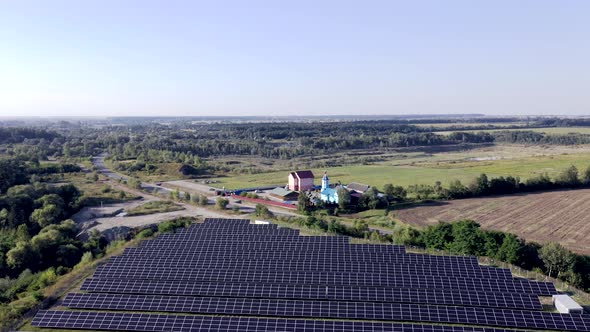 Solar panels among nature. Long rows of blue photovoltaic panels on the field