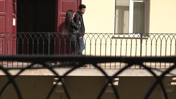 Young couple walking on a balcony alt