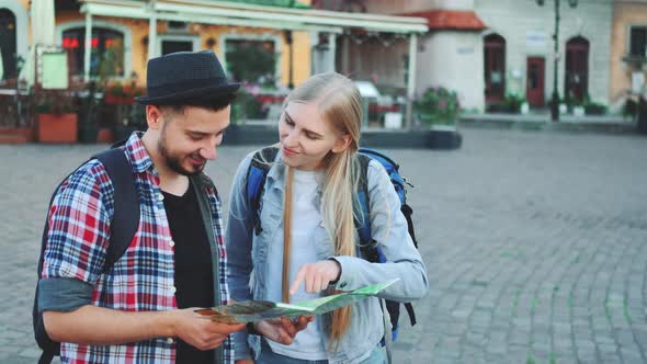 Trendy Couple of Tourists Finding Necessary Destination on Map and Admiring Surroundings