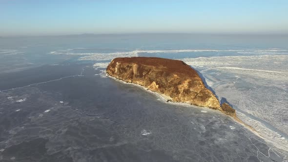 Drone View of a Rocky Island Among the Ice-covered Winter Sea