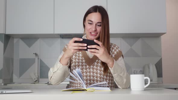 Young Brownhaired Woman Having Fun Playing Phone