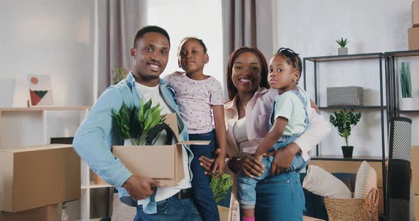 African American Family with Two Small Girls which Standing in New Bought Apartment