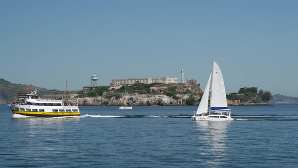 Ferry and Sailboat passing by Alcatraz Island in San francisco