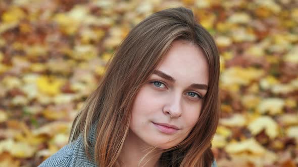 Portrait of a Young and Beautiful Girl Against a Background of Yellow Leaves. Face Close Up