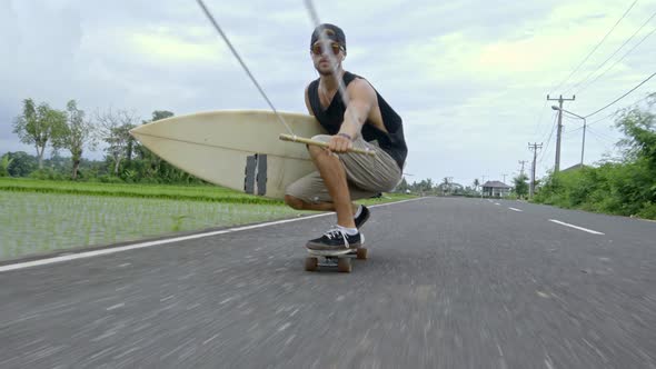 Surfboarder Skitching on Skateboard in Bali