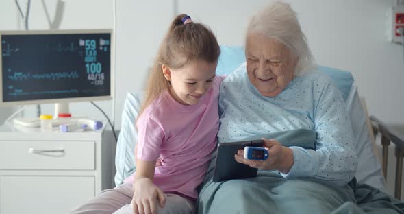 Lovely Girl Visit and Encourage Grandmother on Patient Bed in Hospital