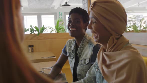 Young adult female friends hanging out in a cafe