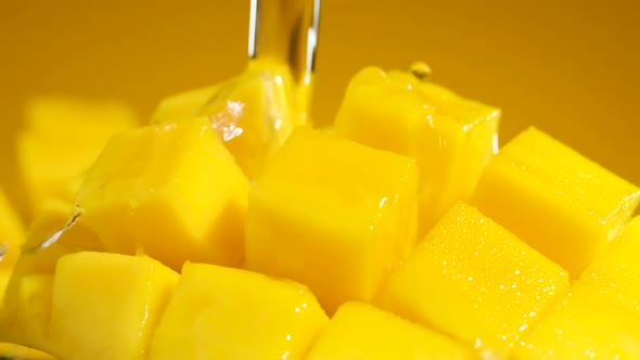 Extreme macro shot of Water Splash Falling on Fresh Mango cubes, Slow motion