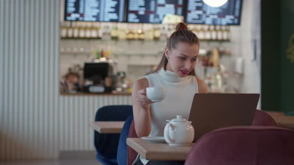 Attractive Longhaired Girl Messaging and Chatting in Cafe