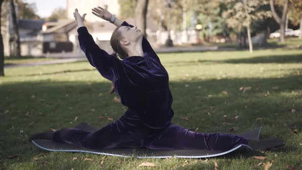 Workout of Flexible Slim Caucasian Woman Outdoors on Sunny Summer Day