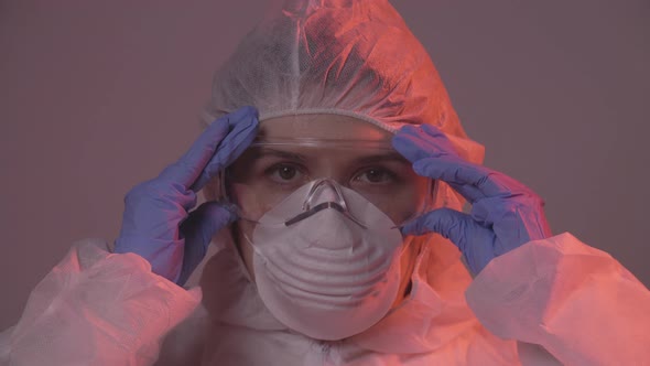 Professional Female Doctor in Mask Standing in Hospital Room Putting Glasses On. Health Care Concept