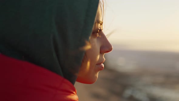 Close Up Portrait of Young Adult Woman Traveler Looking at Sunrise at Sea Beach