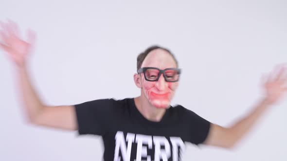 Studio Shot of Nerd Man Wearing Scary Mask and Eyeglasses