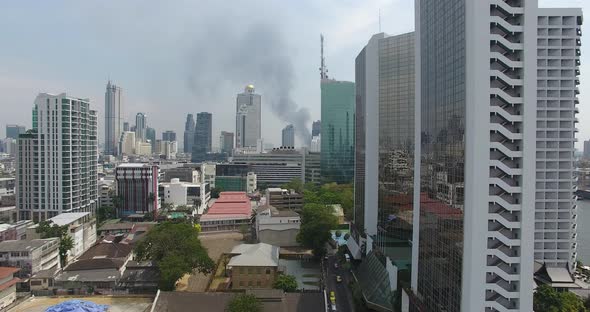 Aerial footage of Bangkok skyline with a fire in the distance.