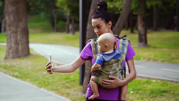 Woman with Baby Recording Video for Blog About Parenting