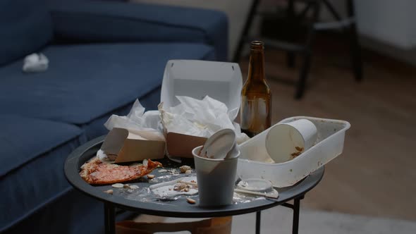 Close Up of Messy Table Leftover Food Dirty Dishes in Empty Living Room