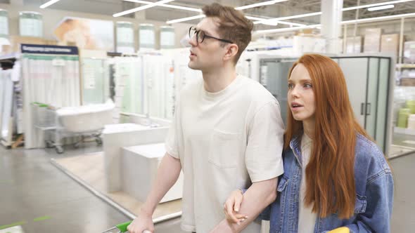 Good-looking Couple in Market Aisle, Looking for Things They Need