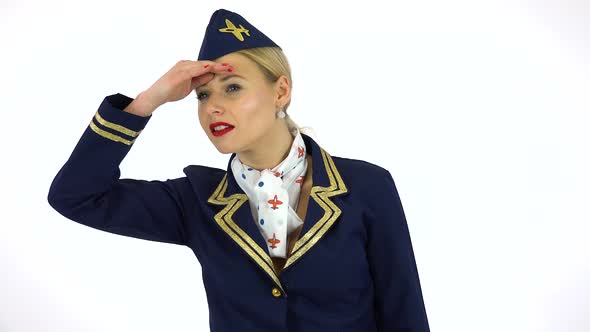 A Young Beautiful Stewardess Protects Her Eyes From the Sun and Looks Around - White Screen Studio