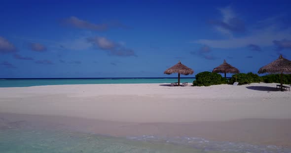 Daytime above island view of a white paradise beach and blue ocean background in colourful 4K