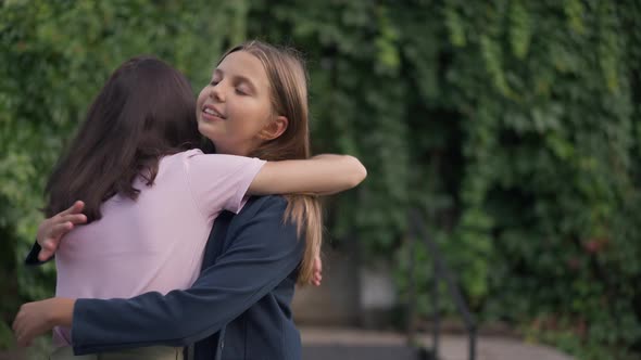 Hypocritical Insincere Teenage Girl Hugging Friend with Annoyed Facial Expression