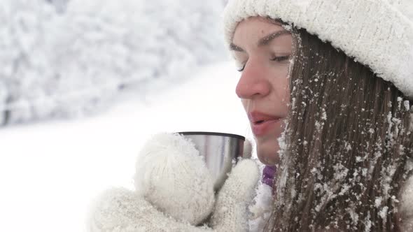 Portrait of a Beautiful Young Woman Who Drinks Some Hot Drink After a Snowball Fight
