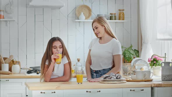 Caucasian Mother Mommy Puts Plate of Cookies on Table Hugging Cuddling Talks with Beloved Daughter